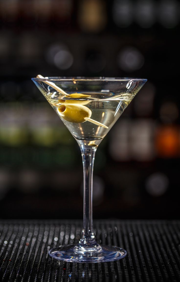 a martini glass with an olive garnish on the rim