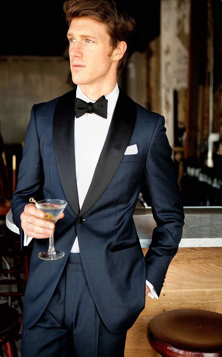 Inspired by James Bond's iconic tuxedo, it features a midnight blue twill wool with the standard tuxedo satin trimmings on the lapel, pocket besom, buttons and pant outseam. The one button dinner jacket is half canvassed with a black paisley lining, the trousers come with adjustable side tabs and suspender buttons. Midnight Blue Tuxedo Wedding, Blue Tuxedo Wedding, Navy Groom, Blue Tux, Navy Tuxedos, Blue Tuxedo, Prom Blazers, Navy Blue Tuxedos, Wedding Tux