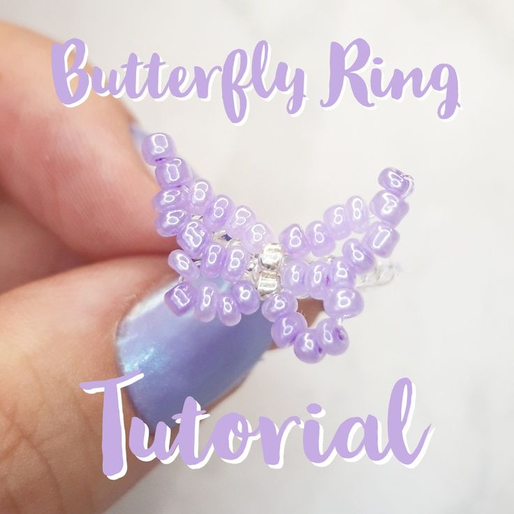 a hand holding a purple beaded ring with the words, butterfly ring on it