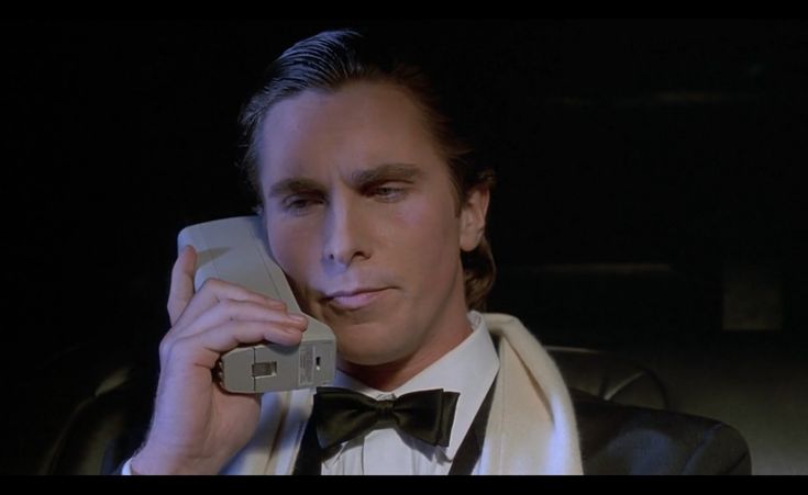 a man in a tuxedo talking on a cell phone