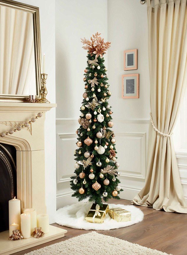 a decorated christmas tree in the corner of a living room next to a fire place