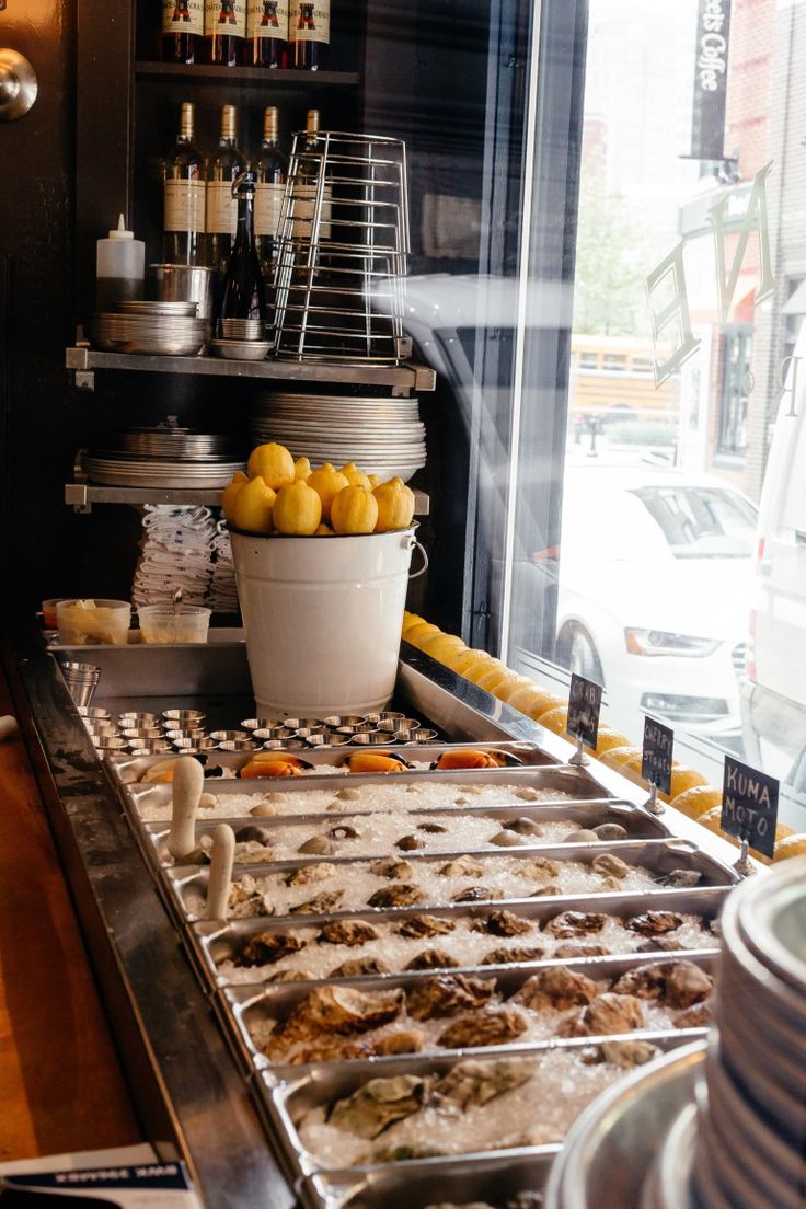 a buffet filled with lots of food next to a large window on the side of a building