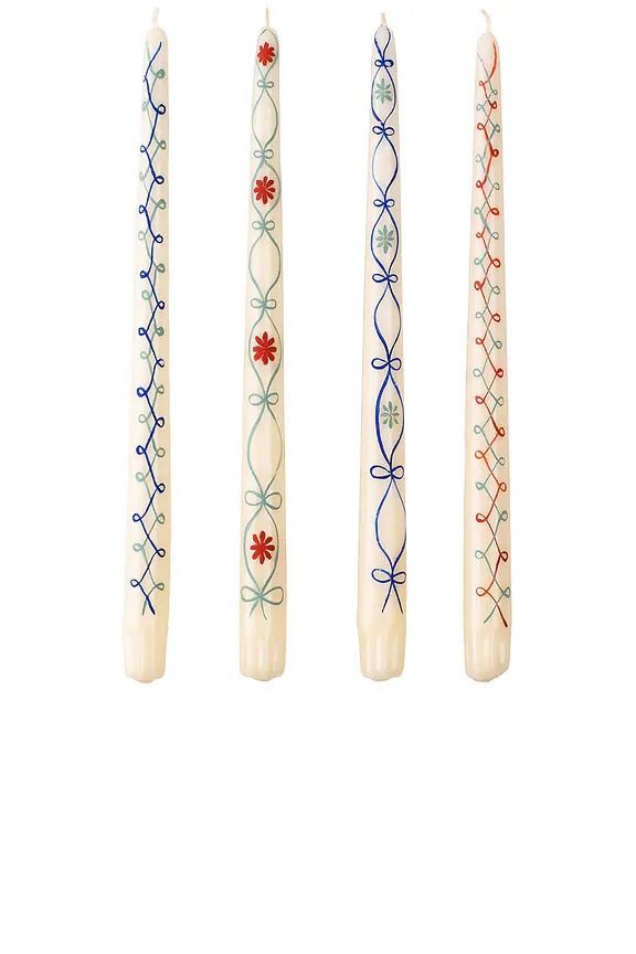 four candles with designs on them are lined up