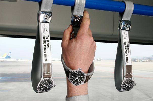 a man is holding onto the handle of a bus with two watches on his wrist