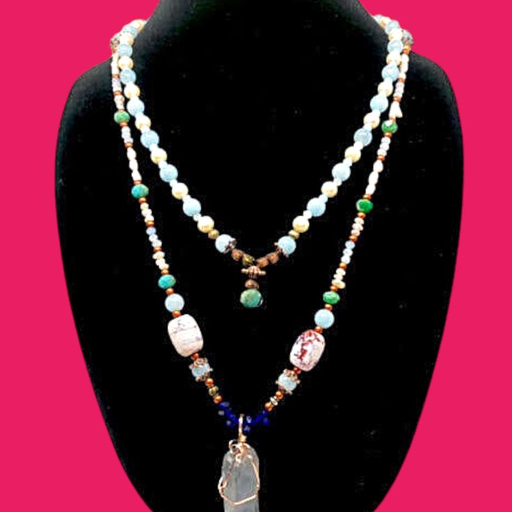 This exquisite necklace is a true masterpiece. The jade beads boast a deep green hue that exudes both a sense of tranquility and vitality. The pearls, on the other hand, are a gentle white that lends an air of sophistication. The quartz pendant is a clear crystal that glows like magic, reflecting light in a mesmerizing manner. The copper ornamentation, meanwhile, imparts a hint of refinement and warmth. This necklace is perfect for the woman who desires to feel confident and beautiful, and who wishes to make a statement. Whether you're dressing up for a special occasion or simply running errands, this necklace will infuse your ensemble with a touch of glamour. When you don this necklace, you'll feel like royalty. You'll feel empowered and beautiful, as if you could conquer anything. Elegant Jade Crystal Necklace With Round Beads, Elegant Jade Crystal Necklaces With Round Beads, Elegant Beaded Jade Crystal Necklaces, Elegant Beaded Jade Crystal Necklace, Handmade Elegant Amazonite Necklace, Amazonite Necklace With Polished Beads As Gift, Elegant Amazonite Gemstone Beads Jewelry, Elegant Beaded Amazonite Jewelry, Spiritual Jade Jewelry With 108 Beads