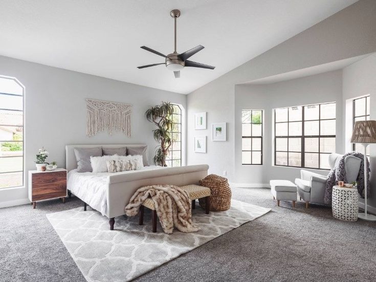 a large bedroom with white walls and carpeted flooring