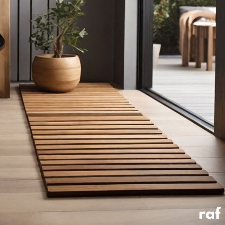 a potted plant sitting on top of a wooden mat in front of a door