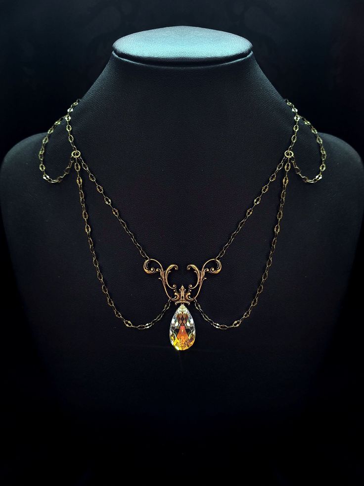 a mannequin with a necklace on it and a pendant hanging from the neck