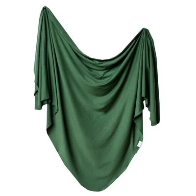 a green cloth draped over the top of a white wall in front of a white background