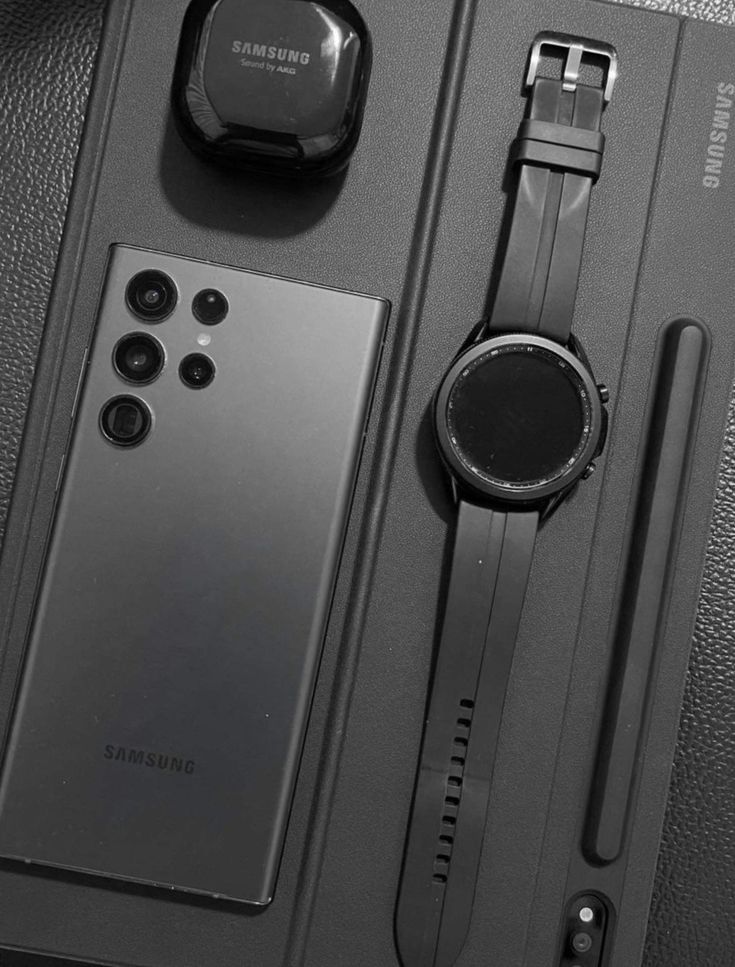 the samsung watch is sitting next to its accessories