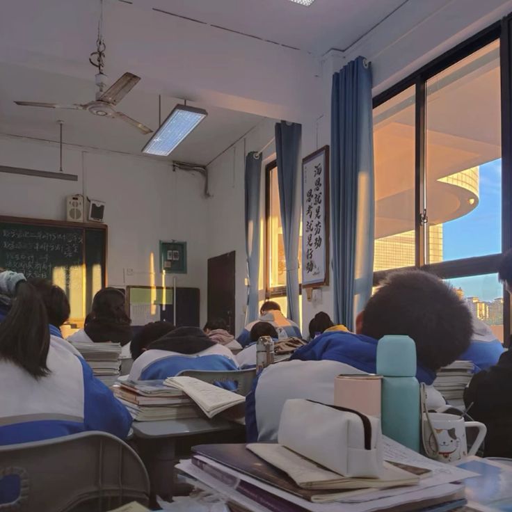 there are many students sitting at desks in the classroom with their backs to the camera