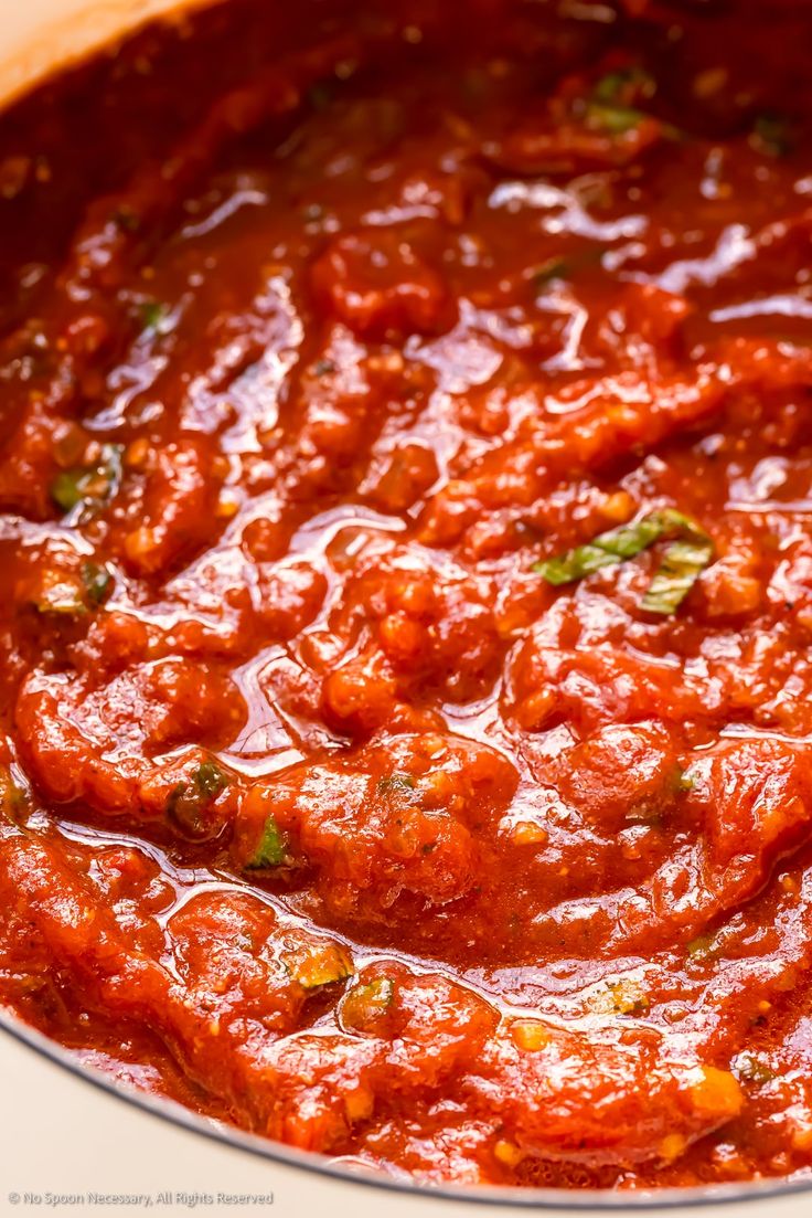 a pot filled with red sauce on top of a stove