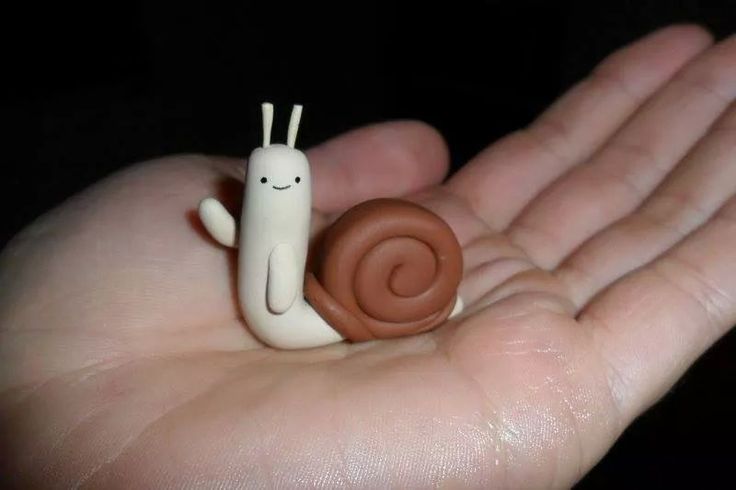 a hand holding a tiny snail toy in it's palm