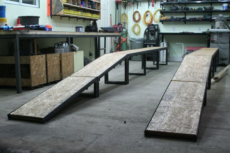 an empty garage with two benches in the foreground and shelves on the far wall