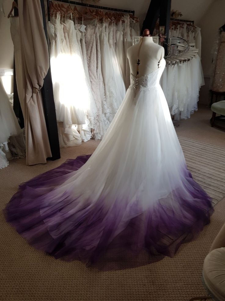 a wedding dress on display in a bridal gown shop with purple and white tulle skirt