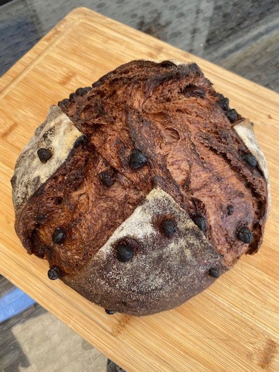 a loaf of bread sitting on top of a wooden cutting board