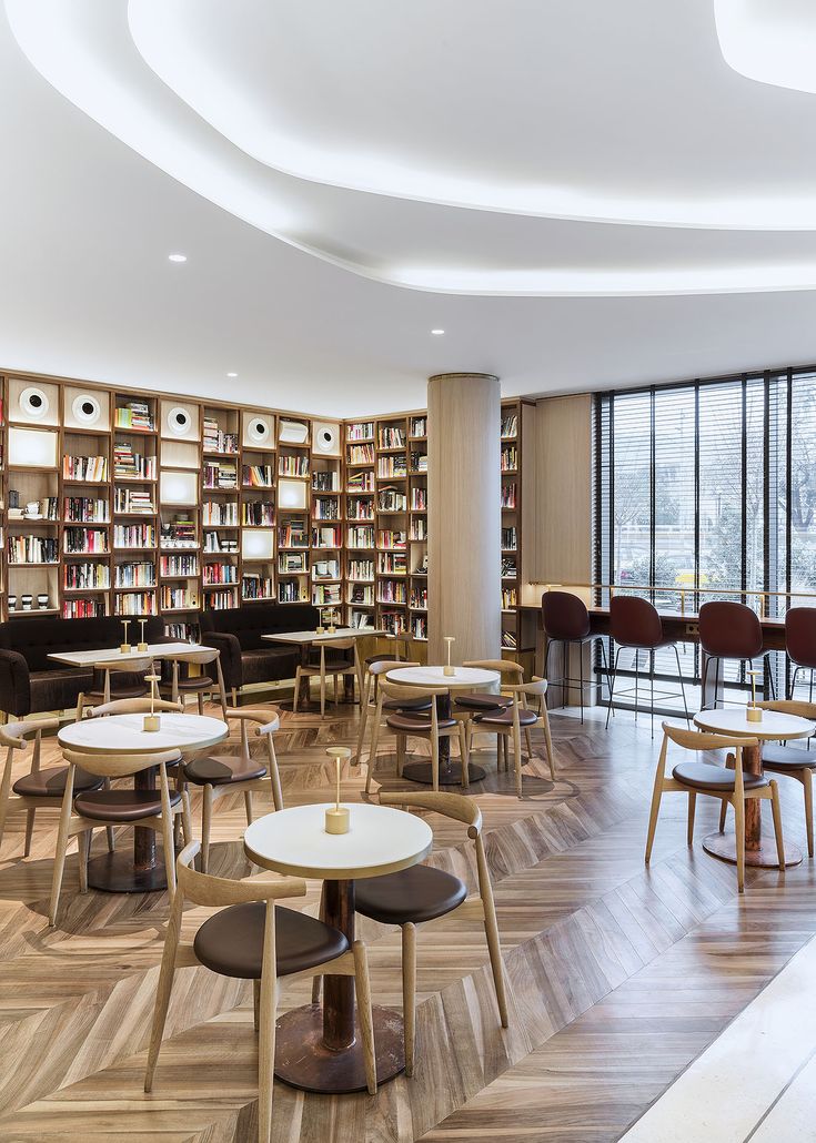 an empty library with tables, chairs and bookshelves