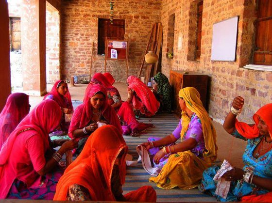 women in colorful sari sitting on the floor