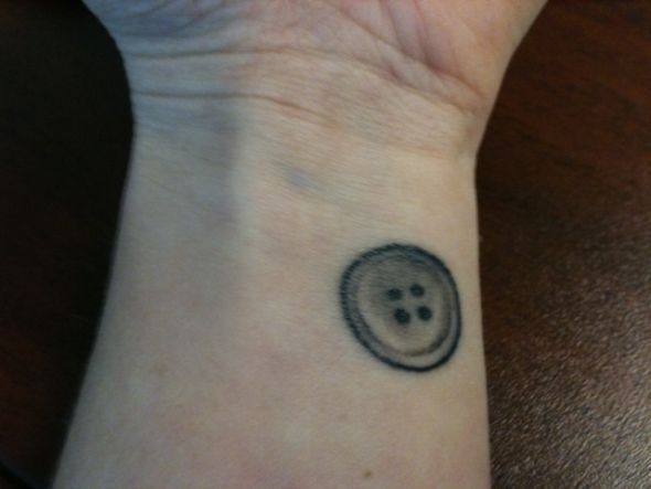 a person with a smiley face tattoo on their wrist