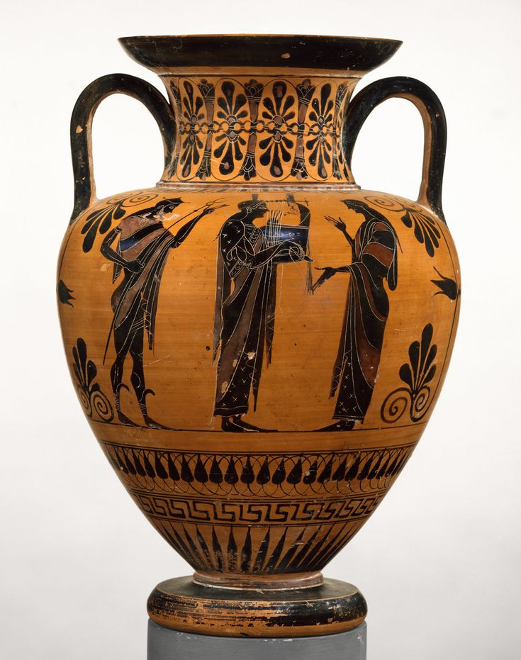 an old vase with people on it is sitting on a pedestal in front of a white wall