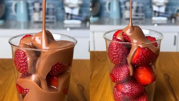 two glasses filled with chocolate and strawberries on top of a wooden table next to each other