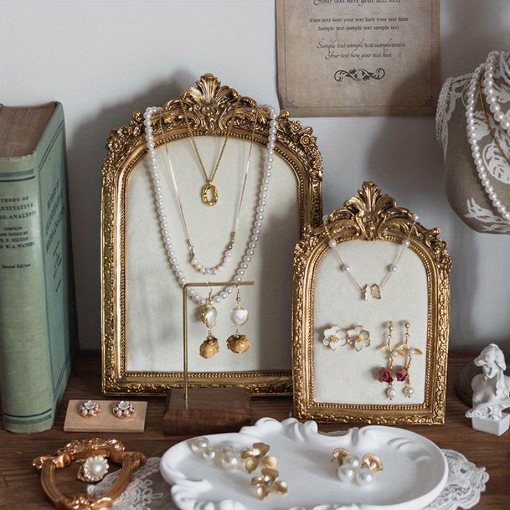 there are three pieces of jewelry on the table next to some books and an old book