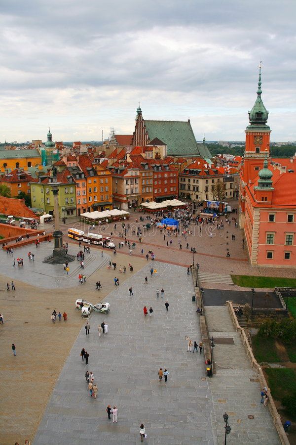 an aerial view of people walking around in the middle of a square with many buildings