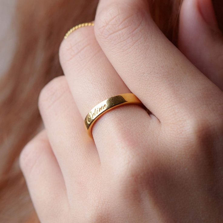 a close up of a person wearing a gold ring