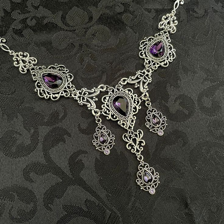 This romantic necklace features richly detailed antiqued silver filigrees, scrolls and beaded accents. Adorned with sparkling dark amethyst purple glass crystals, its breath taking design will add Victorian elegance to your outfits. Decorated portion is 8 1/4" wide and 2 3/4" tall in the very center.  Necklace length is adjustable with soldered stainless steel cable chain, lobster clasp and extender. If you would like a different length, please send us a message. Matching headpiece and earrings Gothic Metal Necklace With Intricate Design, Gothic Filigree Necklace For Wedding, Gothic Filigree Wedding Necklace, Gothic Wedding Necklace With Filigree Detail, Gothic Antique Silver Jewelry With Intricate Design, Gothic Filigree Metal Jewelry, Gothic Metal Jewelry With Filigree, Gothic Antique Silver Filigree Jewelry, Antique Silver Gothic Filigree Jewelry