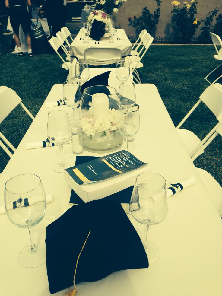 the table is set up for an event with white chairs and black napkins on it