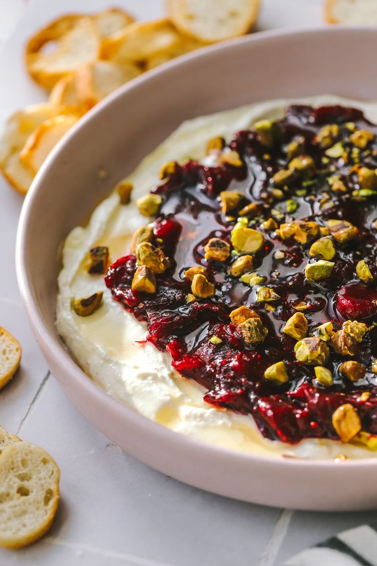 a white bowl filled with food next to crackers