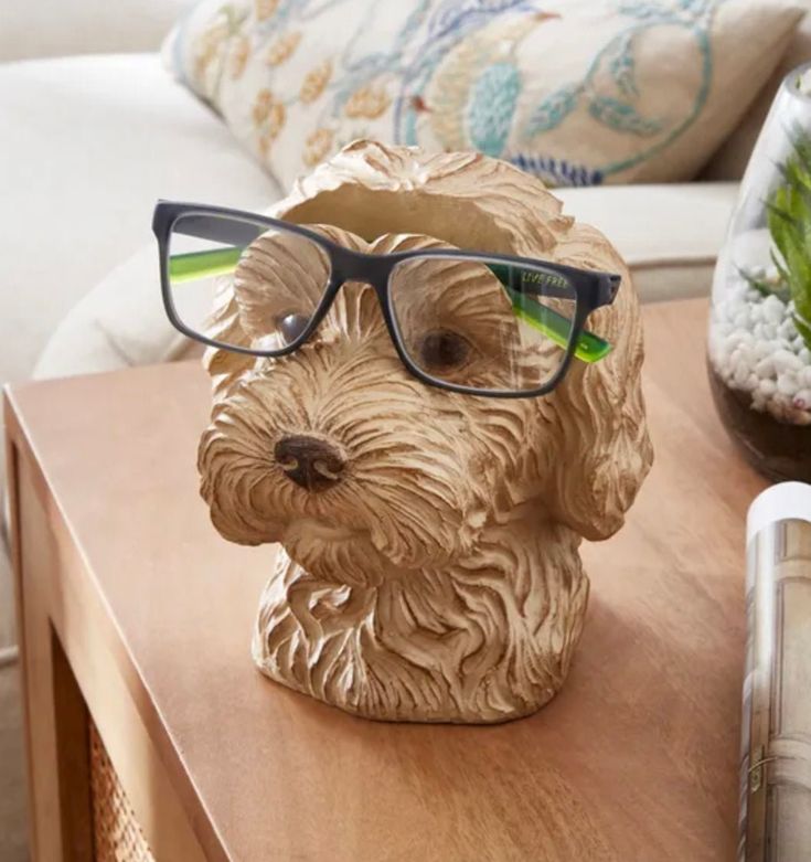 Glasses Holder Additional Storage Space Cockapoo Design Comprised of Resin Never worry about losing your glasses again with this highly-detailed cockapoo glasses holder - an ideal piece to enhance, and brighten, your living space. Comprised of resin, this holder is multifunctional and, with its back storage pocket, also doubles up as a stationery container. With its fun design, this decor is perfect for mantelpieces, end tables and windowsills. Product Dimensions H 16.5cm x W 14cm x D 16cm Compo Dog Holder, Fake Flowers Decor, Glasses Stand, Storage Desk, Pencil Storage, Glasses Holder, Flowers Decor, Christmas Tree Baubles, Eyeglass Holder