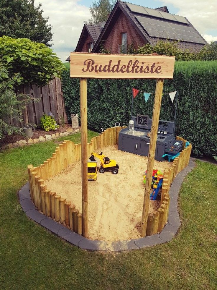 an outdoor play area with sand and toys