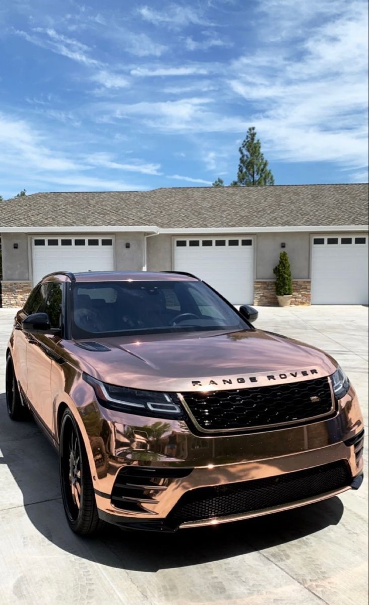 a gold range rover parked in front of a house