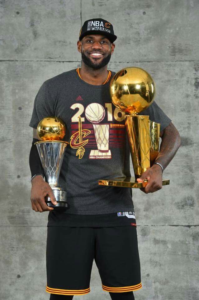 the basketball player is holding trophies in his hands