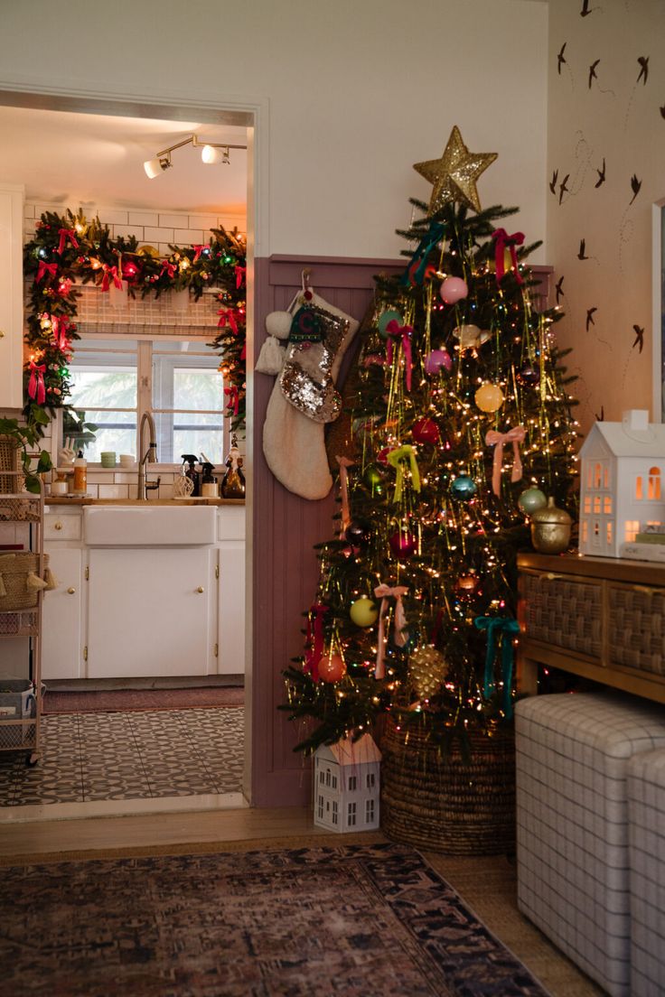 a decorated christmas tree in a kitchen next to a living room and dining room area