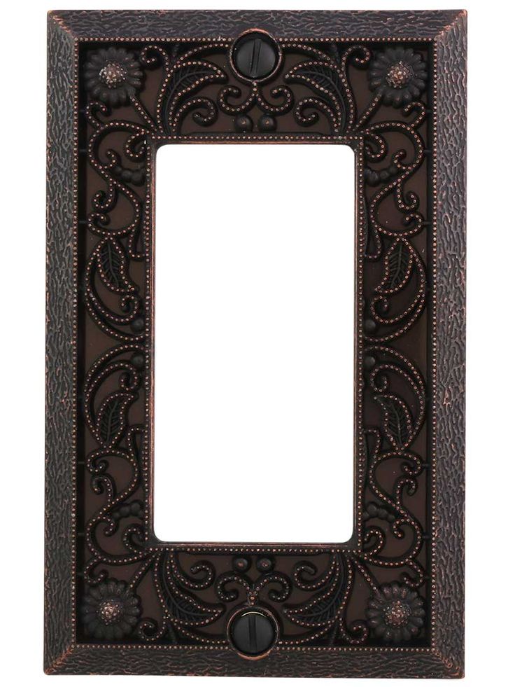 an ornate metal switch plate with a decorative design on the front and back cover,