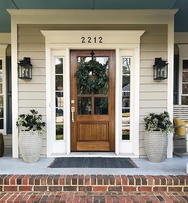 a front door with two planters on either side