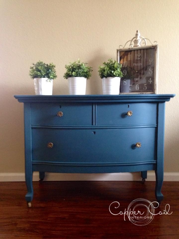 a blue dresser with potted plants on top