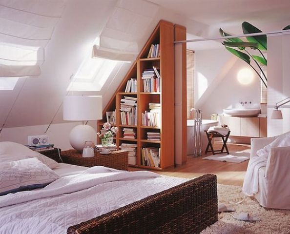 an attic bedroom with a bed, desk and bookshelf