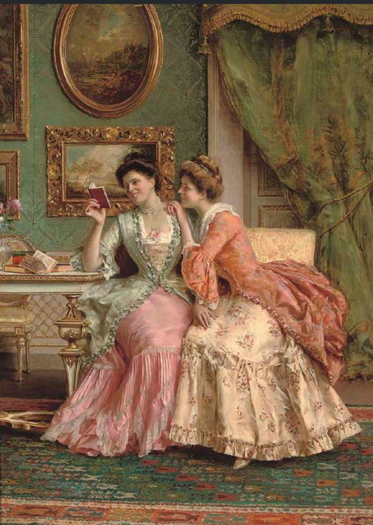 two women in dresses sitting on a couch