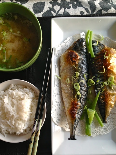 two fish on a plate with rice and chopsticks