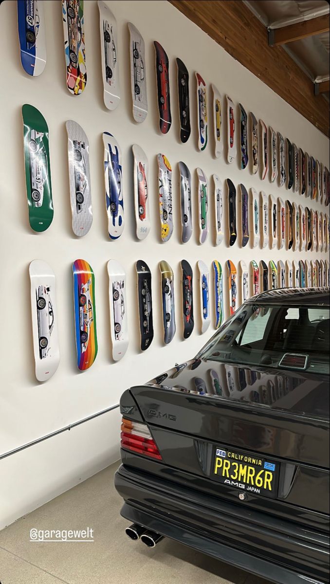 a car parked in front of a wall with skateboards on it's sides