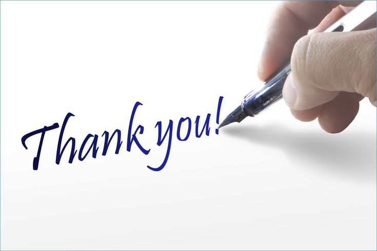 a hand holding a pen writing the word thank you on a piece of paper with blue ink