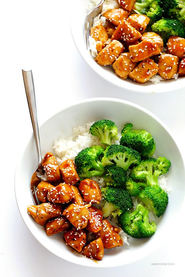 two bowls filled with chicken, broccoli and rice