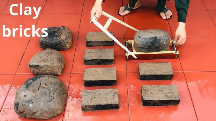 a woman is using a roller to cut rocks on the floor with a pair of scissors