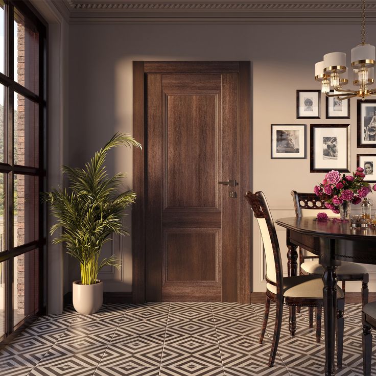 a dining room table and chairs with pictures on the wall above it, next to a potted plant