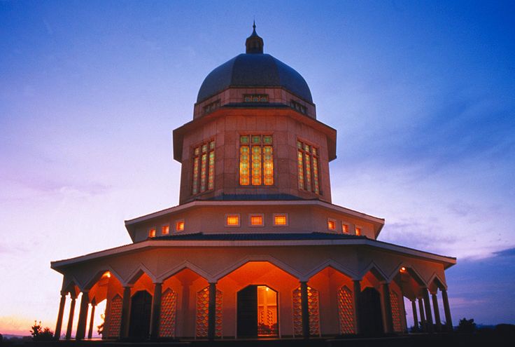 a large building with columns and a dome on the top at sunset or dawn, in front of a blue sky