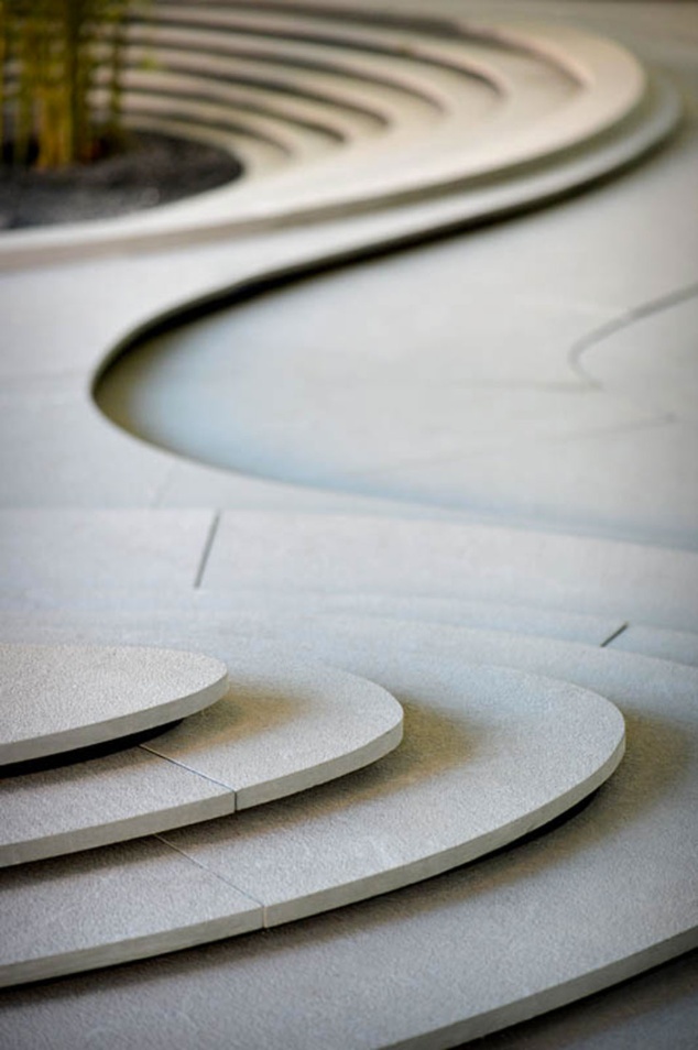 a skateboarder doing a trick in the air over some concrete steps and planters