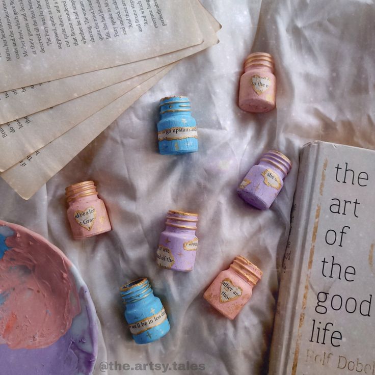 there are many small candys on the table next to a book and some papers